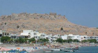 haraki beach beneath the ruins of a crusader castle